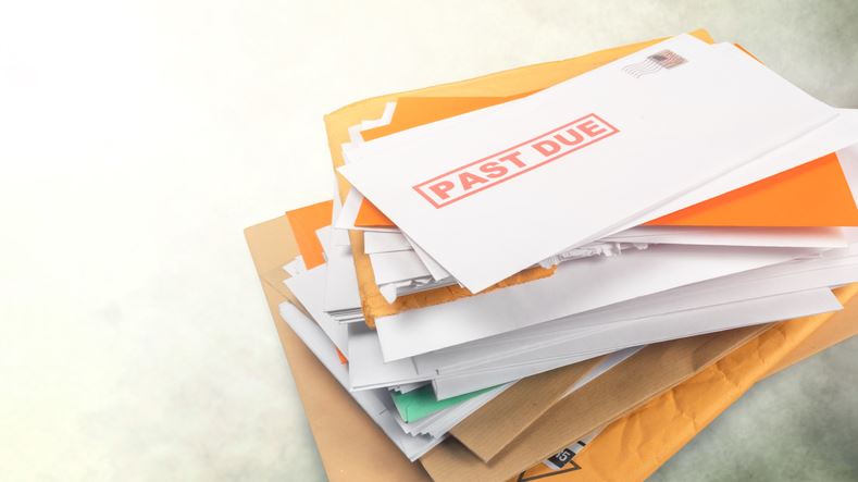 Pile of envelopes with overdue utility bills isolated on white